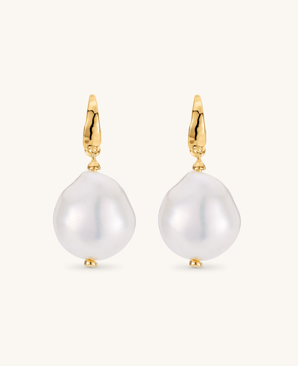 Pearl earrings with gold hooks on a white background