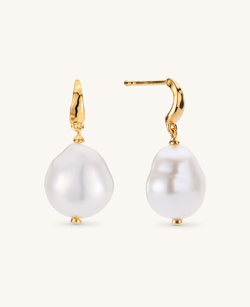 Pearl earrings with gold hooks on a white background