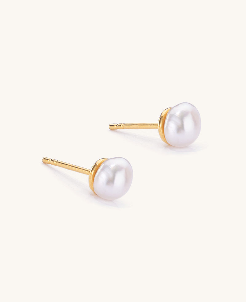 Pair of pearl stud earrings with gold posts on a white background