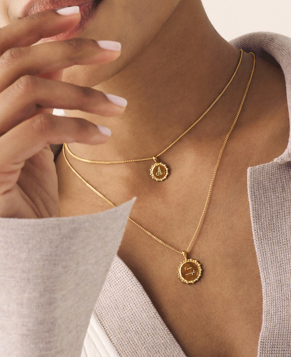 Gold vermeil custom initial necklace layered with engraved name necklace on model, perfect personalised gold jewellery.