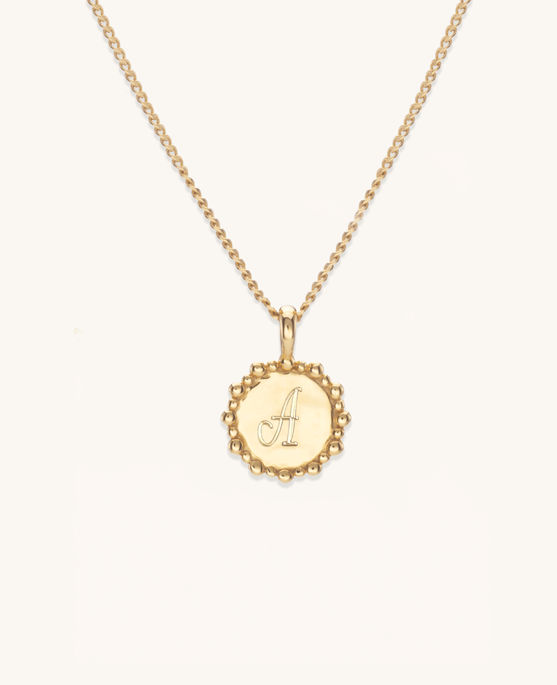 Gold initial necklace with a custom engraved letter A on a gold vermeil chain close up
