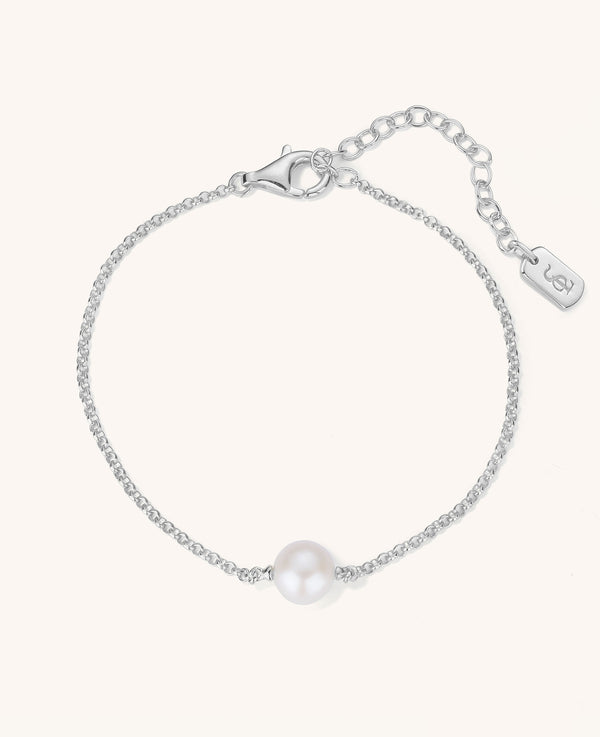 Silver bracelet with a single pearl on a white background