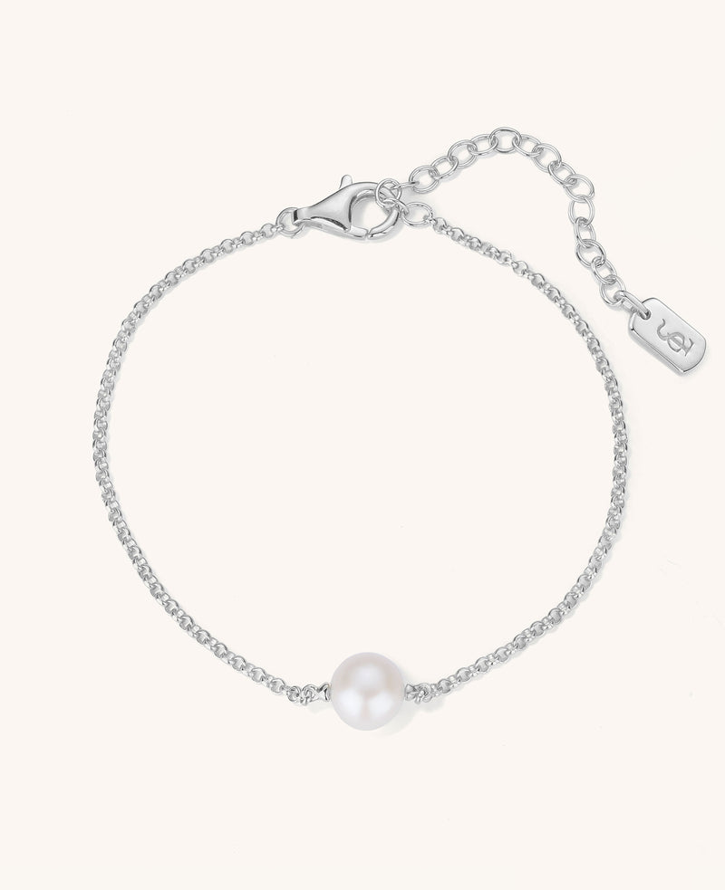 Silver bracelet with a single pearl on a white background