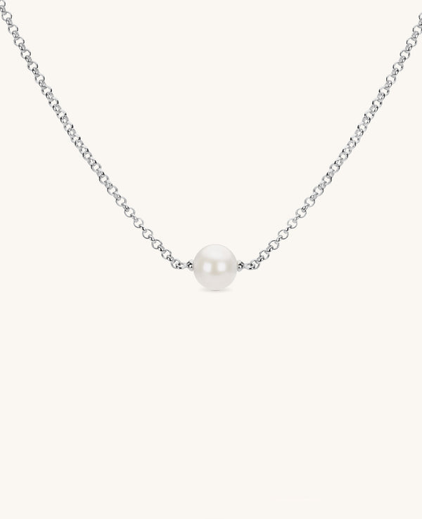 small single round pearl necklace on silver chain on white background